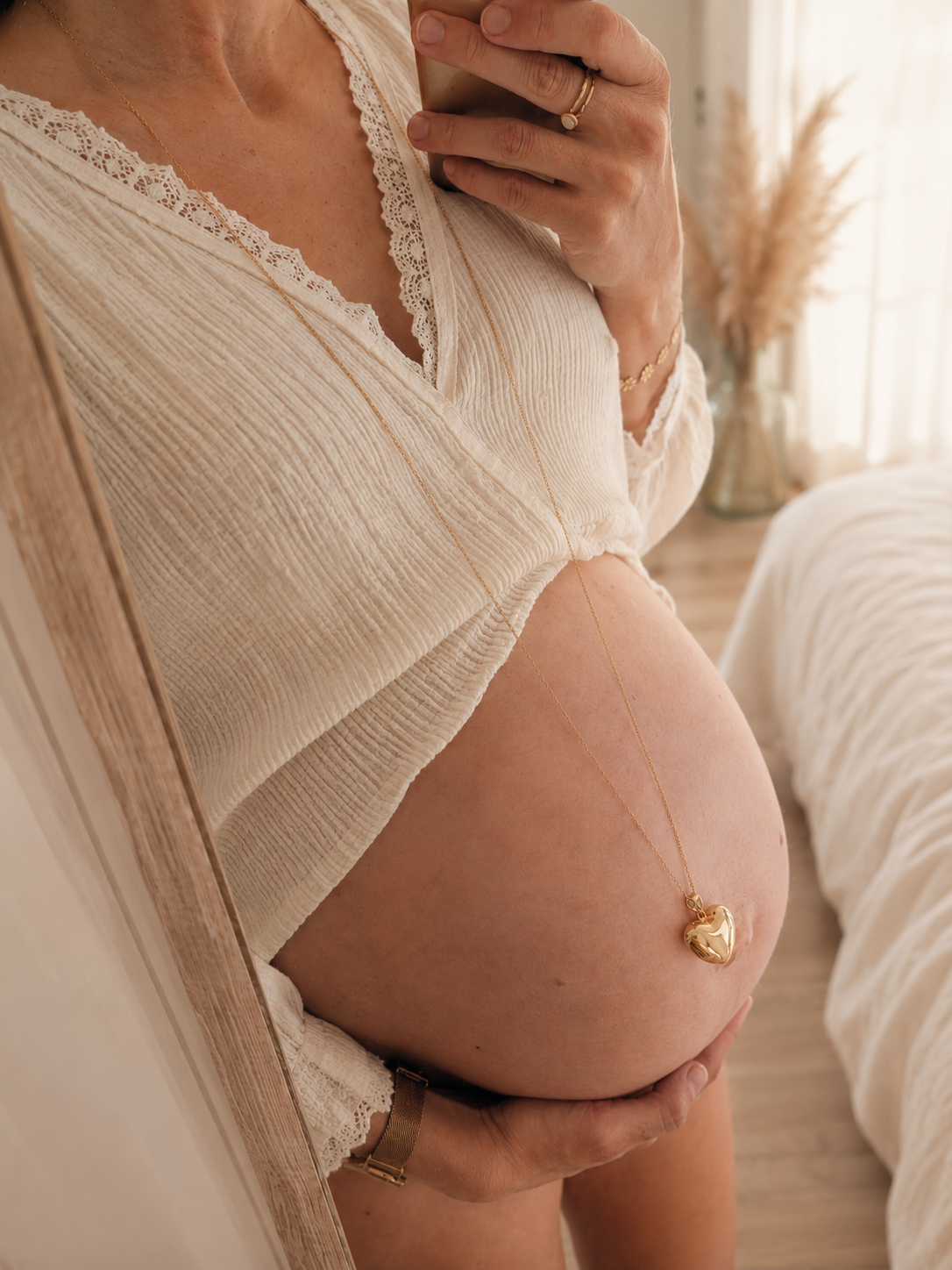 femme enceinte avec un joli bola de grossesse coeur doré dans un ton bohème et doux