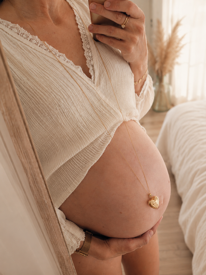 femme enceinte avec un joli bola de grossesse coeur doré dans un ton bohème et doux