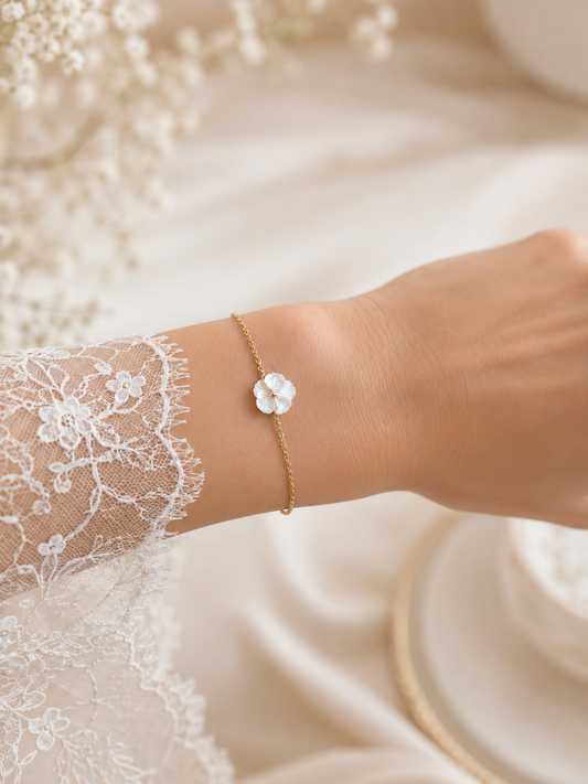 mariée avec un bracelet délicat doré avec une fleur en nacre