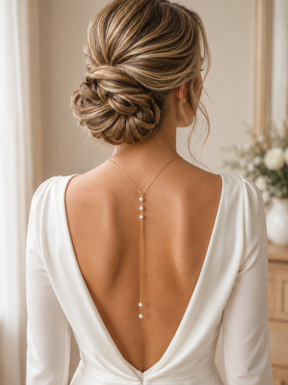 mariée élgante avec robe minimaliste dos nu et collier de dos avec double chaîne pendantes et perles d'eau douce