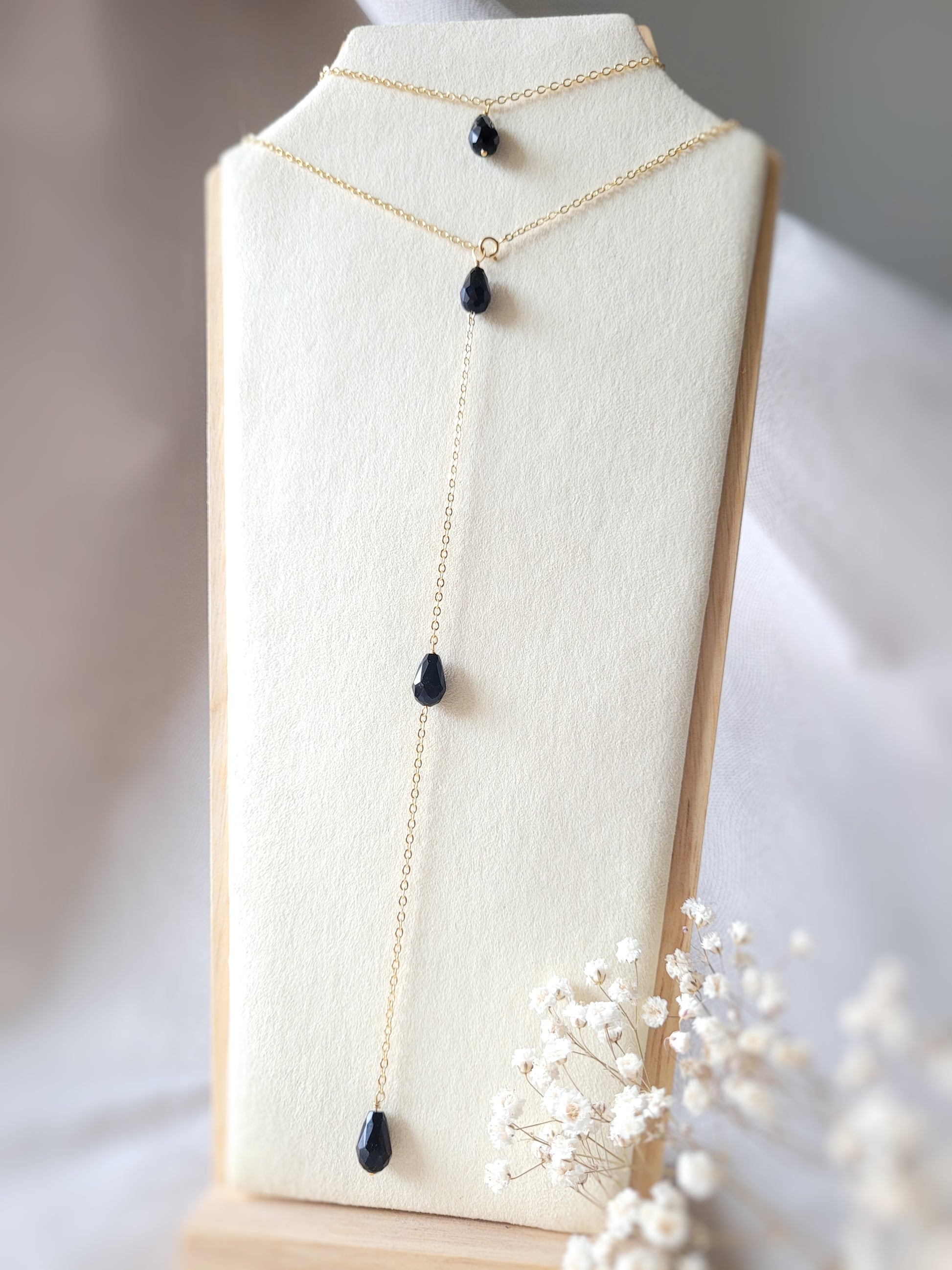 collier de dos triple perles noires pendantes dans le dos